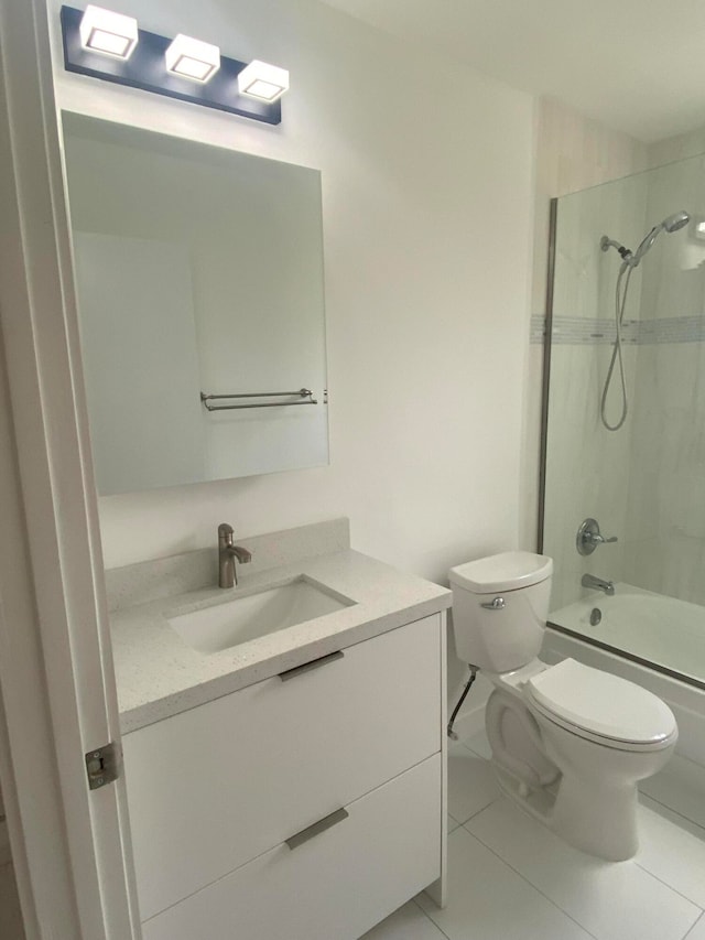 full bathroom featuring tile patterned flooring, tiled shower / bath, vanity, and toilet