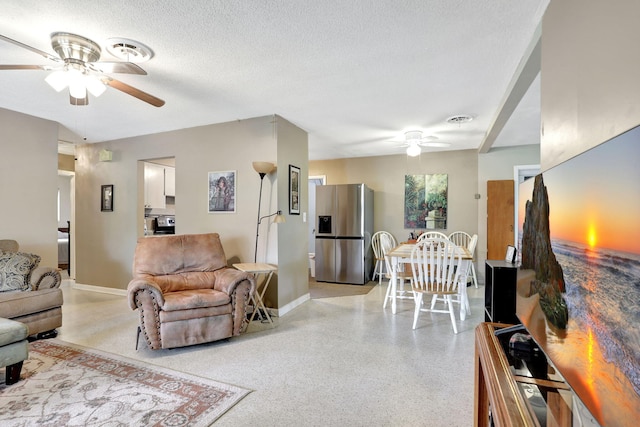 living room featuring ceiling fan and a textured ceiling