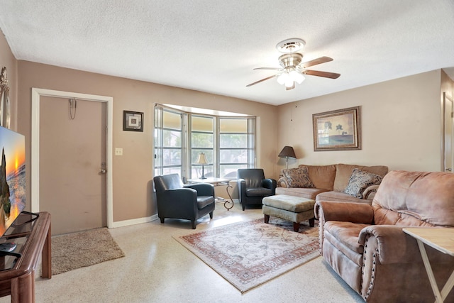 living room featuring ceiling fan and a textured ceiling