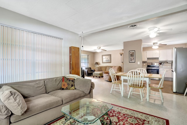 living room featuring ceiling fan and a textured ceiling