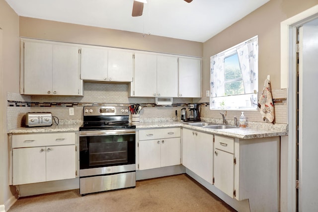 kitchen with stainless steel range with electric cooktop, sink, and white cabinetry