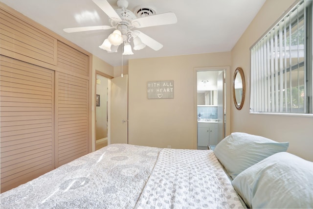 bedroom with a closet, ensuite bathroom, and ceiling fan