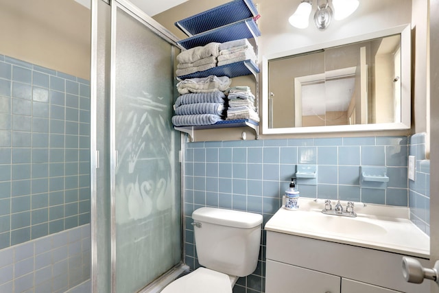 bathroom with vanity, backsplash, a shower with shower door, tile walls, and toilet