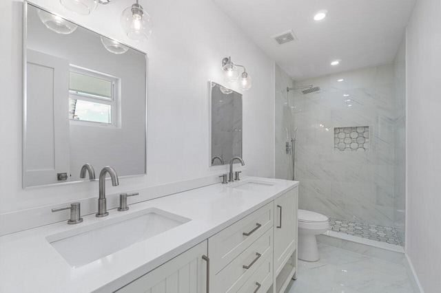 bathroom featuring vanity, tiled shower, and toilet