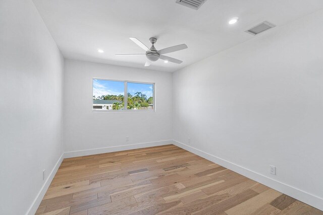 empty room with ceiling fan and light hardwood / wood-style floors