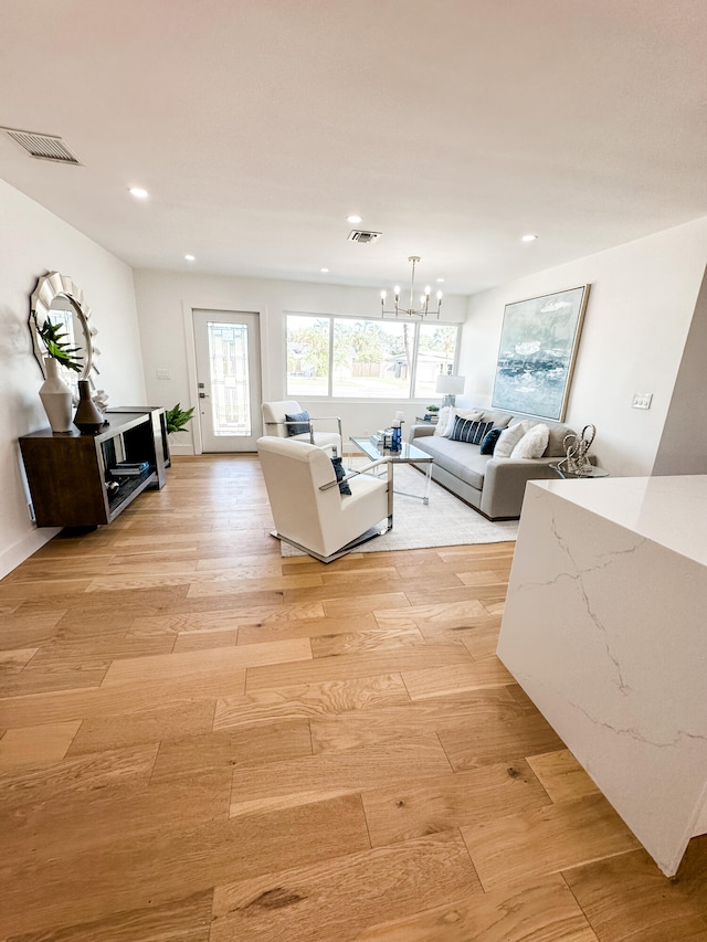 living room with a chandelier and light hardwood / wood-style floors