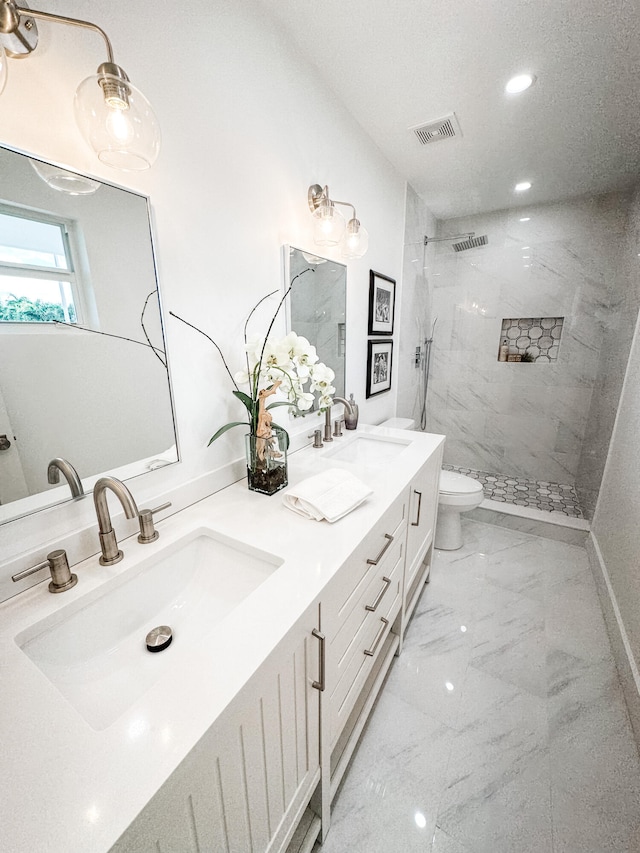 bathroom featuring tiled shower, vanity, and toilet