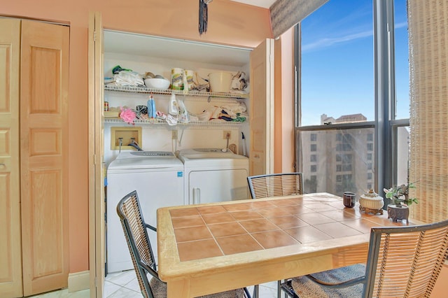 tiled dining room featuring washer and dryer