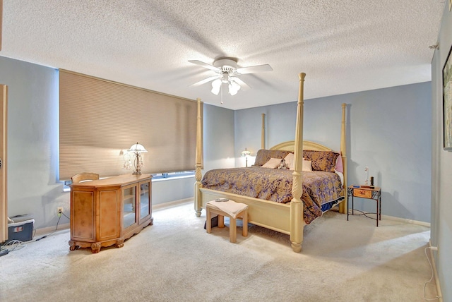 bedroom with a textured ceiling, light colored carpet, and ceiling fan