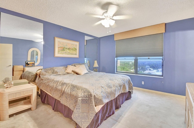 carpeted bedroom with ceiling fan and a textured ceiling