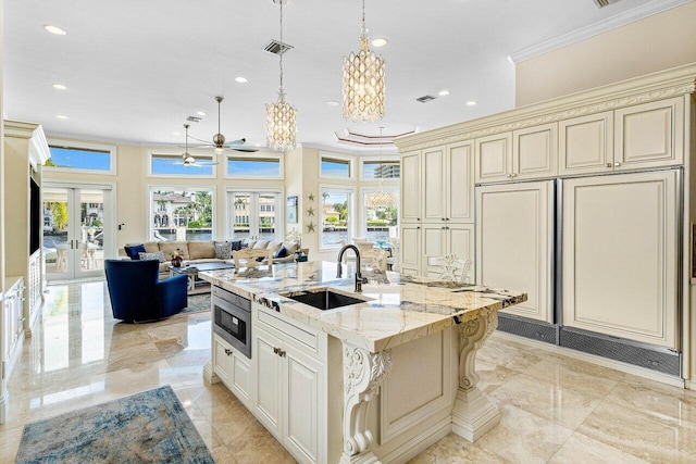 kitchen featuring french doors, cream cabinets, and an island with sink