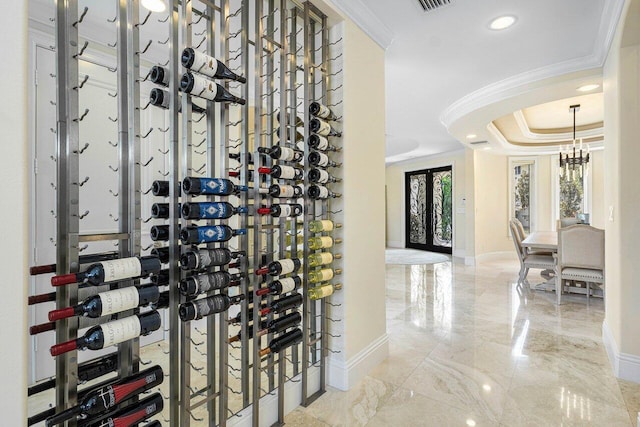 wine area featuring an inviting chandelier and crown molding