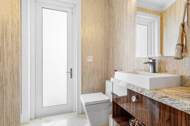 bathroom with toilet, ornamental molding, and vanity