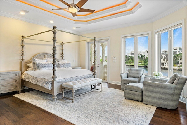 bedroom featuring a raised ceiling, dark hardwood / wood-style flooring, access to exterior, ceiling fan, and ornamental molding