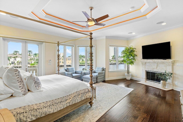 bedroom featuring dark wood-type flooring, a raised ceiling, access to outside, and ceiling fan