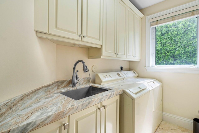 laundry area featuring cabinets, independent washer and dryer, and sink