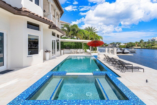 view of swimming pool with an in ground hot tub, a patio, and a water view