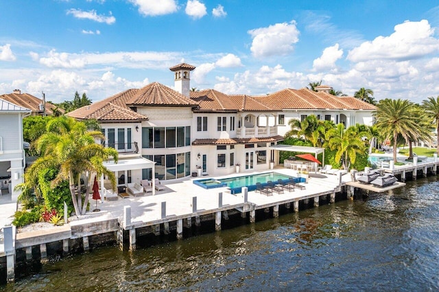 back of house with a patio, a water view, and a balcony