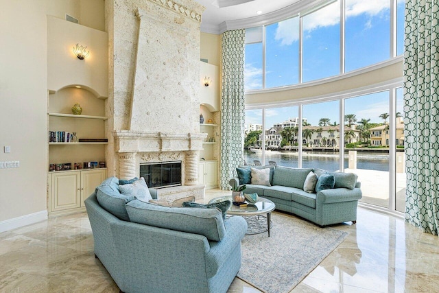 living room featuring a stone fireplace, a water view, plenty of natural light, and built in features