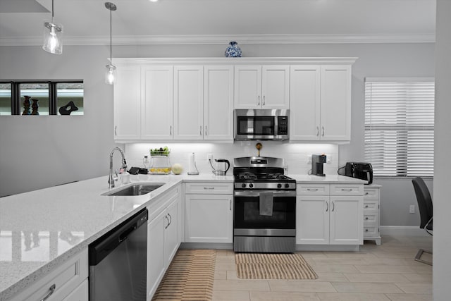 kitchen featuring pendant lighting, sink, crown molding, stainless steel appliances, and white cabinets