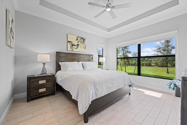 bedroom featuring ceiling fan, ornamental molding, a raised ceiling, and light hardwood / wood-style flooring