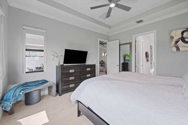 bedroom featuring a raised ceiling, crown molding, ceiling fan, and light hardwood / wood-style flooring