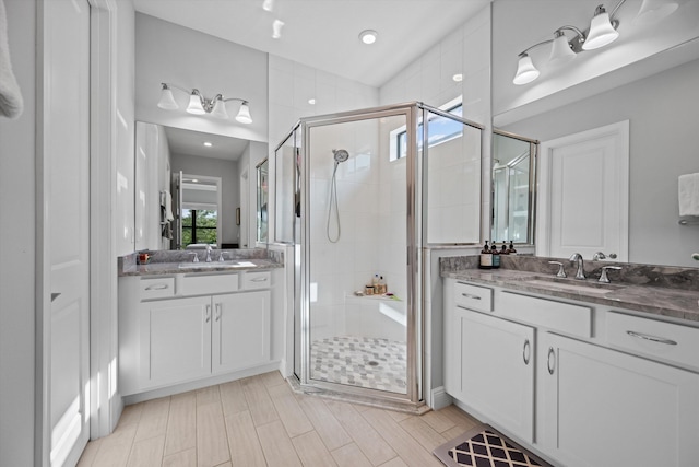 bathroom with a shower with door and vanity