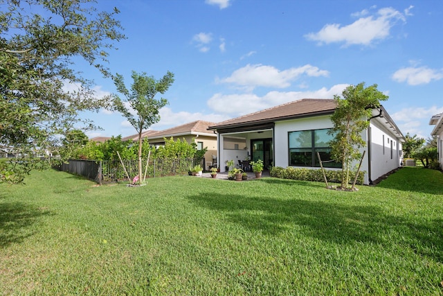 back of house with a yard and a patio