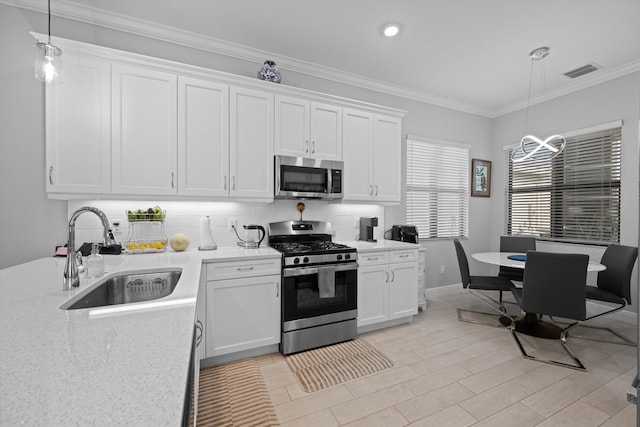 kitchen featuring stainless steel appliances, decorative light fixtures, sink, and white cabinets