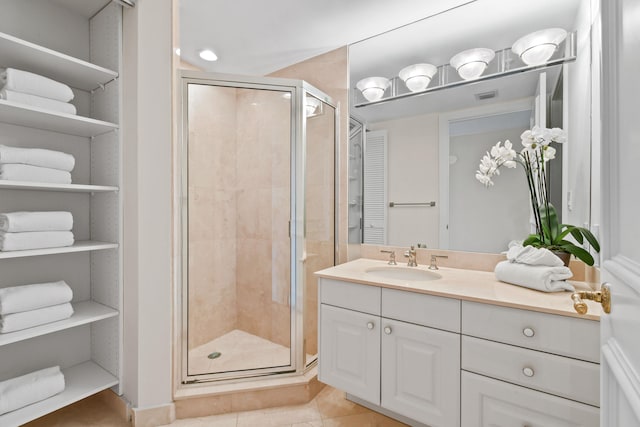 bathroom with tile patterned floors, vanity, and walk in shower