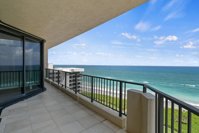 balcony featuring a water view and a beach view