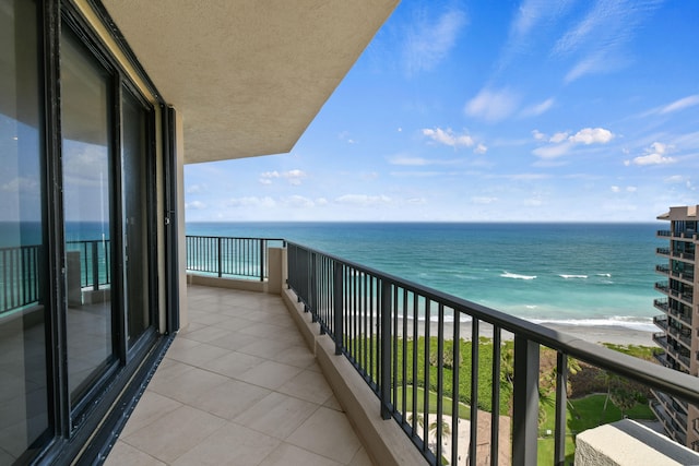 balcony featuring a water view and a beach view