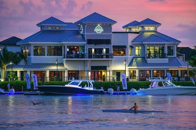 back house at dusk featuring a water view