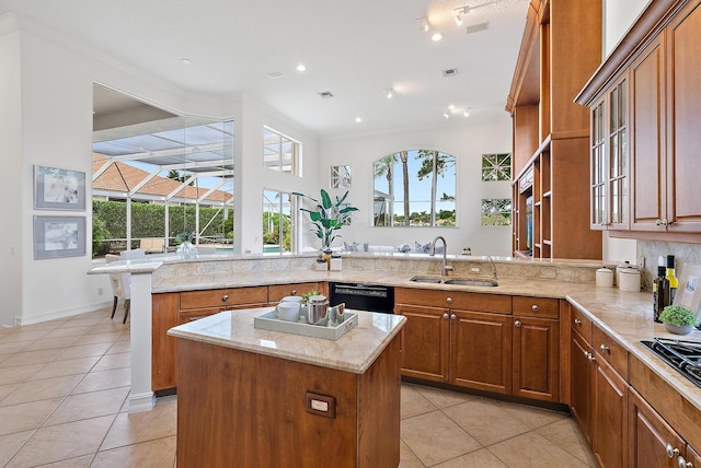 kitchen with kitchen peninsula, black appliances, sink, a center island, and light stone counters