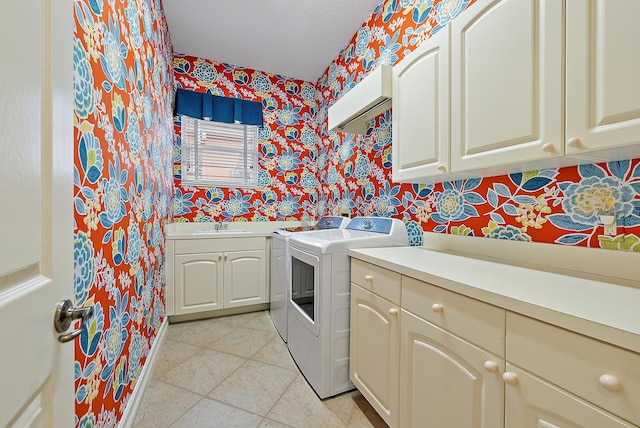 clothes washing area featuring cabinets, washer and dryer, and sink