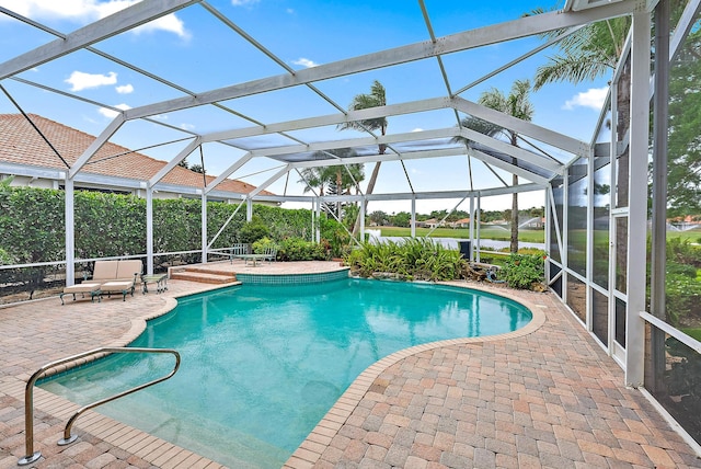 view of swimming pool featuring a patio, a lanai, and a water view