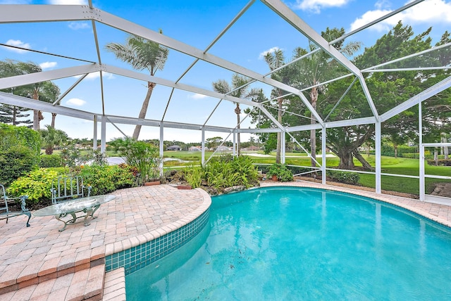 view of pool with a patio and glass enclosure