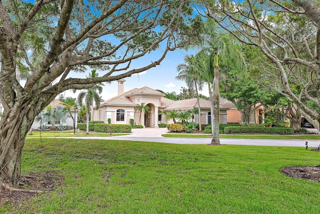 mediterranean / spanish-style house with a front lawn