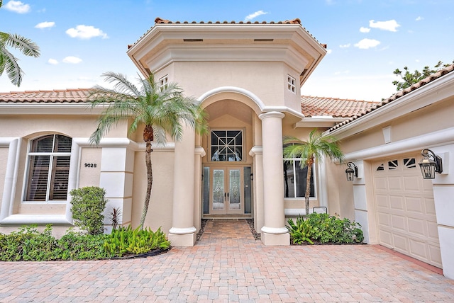 view of exterior entry with french doors and a garage