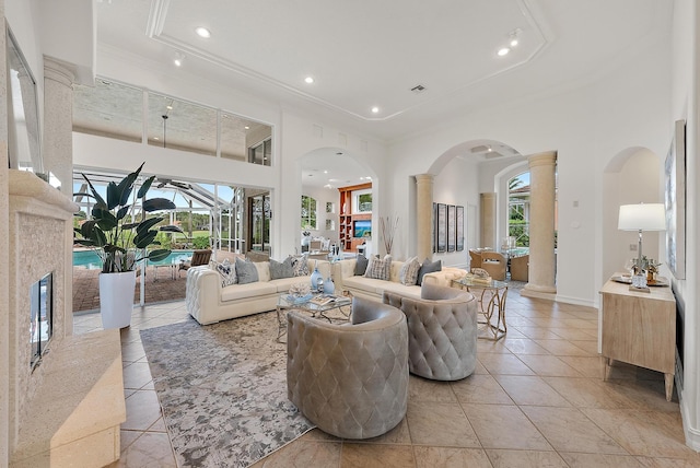 living room with ornate columns, a high ceiling, light tile patterned flooring, and plenty of natural light