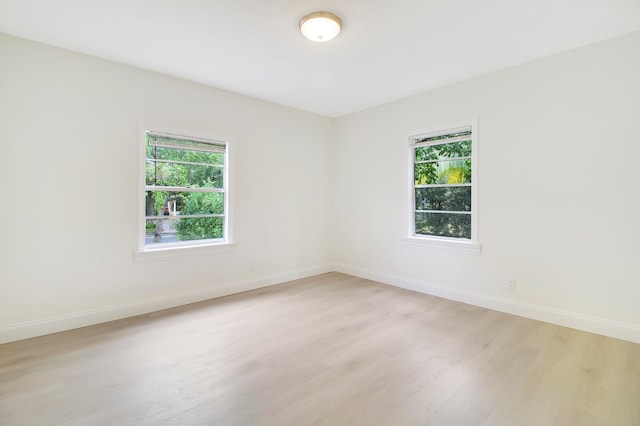 spare room featuring light wood-type flooring and a healthy amount of sunlight