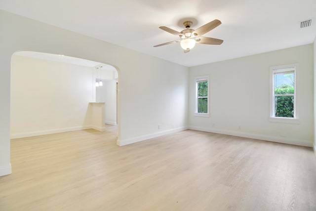 empty room with ceiling fan, light hardwood / wood-style flooring, and plenty of natural light