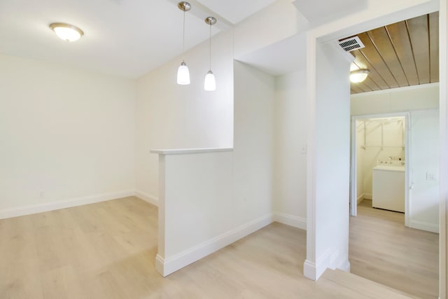 interior space with washer / dryer, wood ceiling, and light hardwood / wood-style flooring