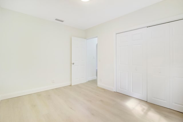 unfurnished bedroom featuring light wood-type flooring and a closet