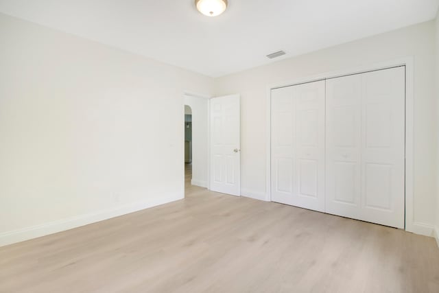 unfurnished bedroom featuring a closet and light wood-type flooring