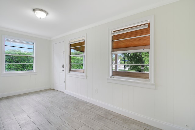 unfurnished room featuring ornamental molding, plenty of natural light, and light hardwood / wood-style floors