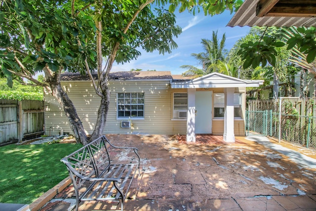 back of house with a lawn and a patio