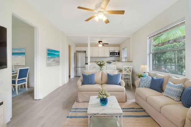 living room with ceiling fan and light hardwood / wood-style flooring