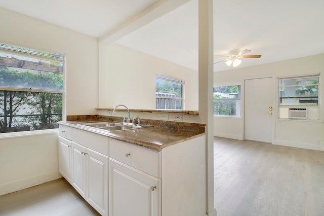 kitchen with cooling unit, white cabinets, sink, kitchen peninsula, and light hardwood / wood-style floors