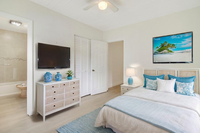 bedroom with ceiling fan, connected bathroom, and light hardwood / wood-style flooring